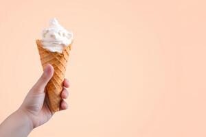 Hand holding delicious vanilla ice cream in a crispy waffle cone with copy space. photo