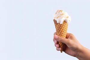 Hand holding delicious vanilla ice cream in a crispy waffle cone with copy space. photo