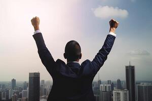 Successful businessman raising hand and expressing positivity while standing against skyscrapers background. photo