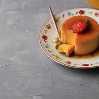 Pudding Caramel Custard with Strawberry on Cement Background photo