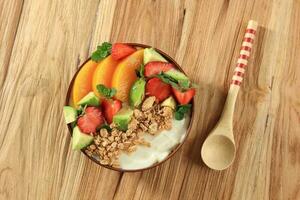 Granola with Greek Yogurt, Peach, Avocado,  and Strawberry in Bowl. photo