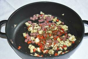 Salami with Apple pieces, herbs and chili to fry photo