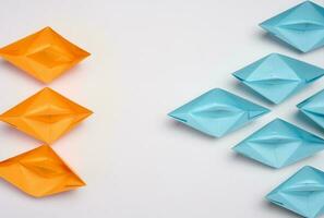 Two groups of paper boats facing each other, a concept of confrontation, top view photo