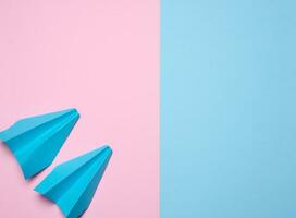 Paper airplane on a blue pink background, travel concept, top view. Copy space photo