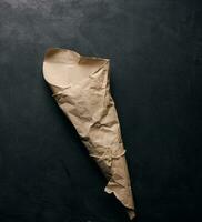 Empty bag of brown craft paper on a black background photo