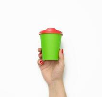female hand holding disposable green paper cup isolated on white background photo