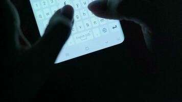 Hands typing text on smartphone close-up. Using smartphone close up at night. Communication concept video