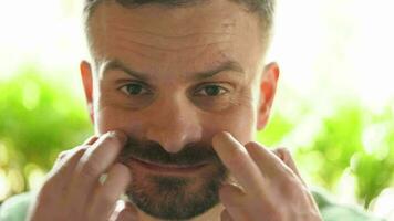 Beau homme avec tordu moustache à la recherche à le caméra video