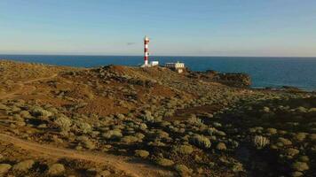 aereo Visualizza di il faro faro de rasca, natura Riserva e il montagne a tramonto su tenerife, canarino isole, Spagna. selvaggio costa di il atlantico oceano. video