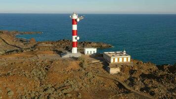 aereo Visualizza di il faro faro de rasca, natura Riserva e il montagne a tramonto su tenerife, canarino isole, Spagna. selvaggio costa di il atlantico oceano. video