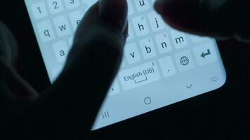 mani digitando testo su smartphone avvicinamento. utilizzando smartphone vicino su a notte. comunicazione concetto video