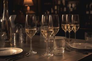 A table in a restaurant has glasses of champagne or white wine arranged on it. photo