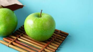 close up of green color apple and a paper bag on table video