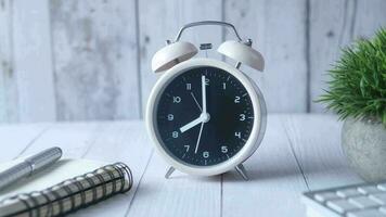 alarme horloge, bloc-notes et stylo sur table video
