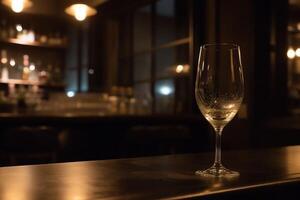 A glass of the champagne or white wine is placed on the counter with background of luxury bar place. photo