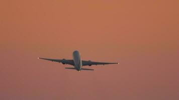 Jet civil aircraft climb, flies in the sunset beautiful sky, long shot. Airliner silhouette departure. Tourism and travel concept video