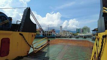 georgetown, penang, Maleisië, nov 16 2021, geel roro veerboot vertrekken penang steiger. achtergrond is oud veerboot en komtar gebouw in blauw zonnig dag video