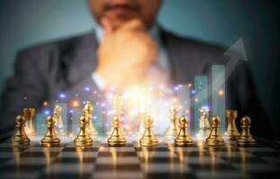 Selective focus of golden chess and success business graph in front of professional business analysis man. Concept of leadership must-have solution for the financial crisis photo