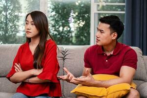 infeliz Pareja sentado junto a cada otro en el sofá y evitar hablando o disputa, porque de relación problemas y teniendo malentendido o desacuerdo. familia problemas concepto foto