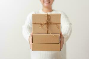 Woman hands holding present box with a ribbon bow. Concept of gift  box minimalist style. Showing brown cardboard boxes delivery someone in special occasions or parcel deliver service. photo