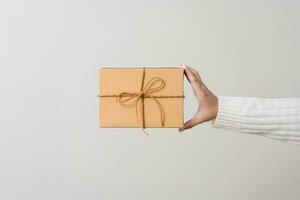 Woman hands holding present box with a ribbon bow. Concept of gift  box minimalist style. Showing brown cardboard boxes delivery someone in special occasions or parcel deliver service. photo