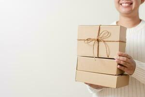 Woman hands holding present box with a ribbon bow. Concept of gift  box minimalist style. Showing brown cardboard boxes delivery someone in special occasions or parcel deliver service. photo