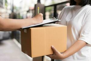 Postal service sending paper cardboard box to customer in front of a house outdoor. Shipping service arrival and send to customer address. photo