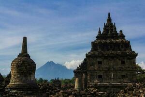 Wide view of Candi Plaosan with Gunung Merapi as the background under bright afternoon blue sky photo