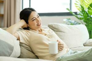 Portrait of a happy asian woman relaxing at home photo