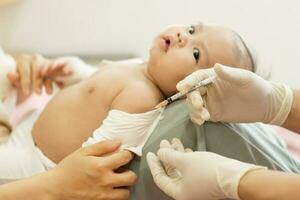 retrato de un bebé siendo vacunado por un médico foto