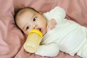 image of a newborn baby lying on a pink bed photo