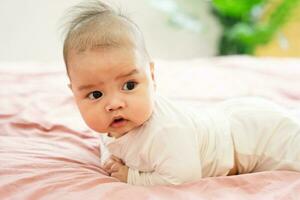 image of a newborn baby lying on a pink bed photo