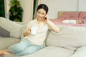Portrait of a happy asian woman relaxing at home photo