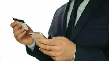 Man in a suit standing in front of a white background using online banking with a smartphone, easy payment using a smartphone or digital device video