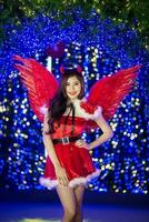 Pretty Asian girl in Santa costume for Christmas with night light photo