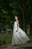 Asian Girl in wedding dress in the forest photo