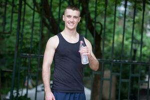 hermoso atleta hombre Bebiendo agua foto