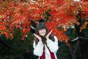 Young Chinese woman in action with autumn leaves photo