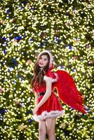 bonito asiático niña en Papa Noel disfraz para Navidad con noche ligero foto