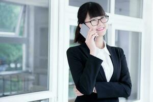 Modern business woman in the office, talking on phone photo