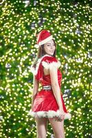 Pretty Asian girl in Santa costume for Christmas with night light photo