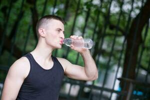 Handsome athlete man drinking water photo
