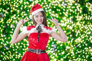 Pretty Asian girl in Santa costume for Christmas with night light photo