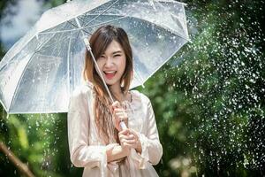 Happy Chinese girl is getting wet and rain photo