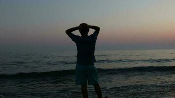 silhueta do triste depressivo homem em de praia durante pôr do sol video