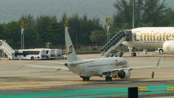 Phuket, Thailand Februar 25, 2023 - - Traktor zieht kommerziell Flugzeug boeing 737 max von Batik Luft beim Phuket Flughafen. Flugzeug Abschleppen, Flugplatz. Tourismus und Reise Konzept video