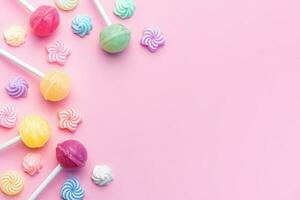 Sweet lollipops and candies on pink background photo