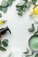 Eucalyptus, towel, massage salt, aroma oil,  spa objects on white tile background. photo