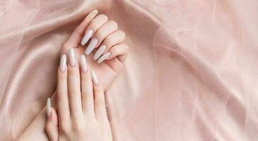 un mujer manos con un manicura en a ellos, el uñas son pintado en un blanco color. foto
