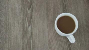 Top view of coffee cup on wooden table background video